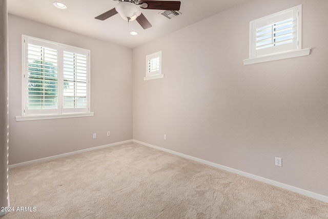 carpeted empty room featuring a wealth of natural light and ceiling fan