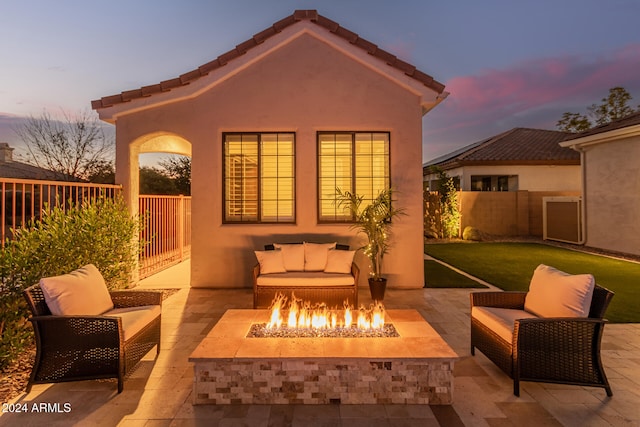 patio terrace at dusk featuring an outdoor fire pit