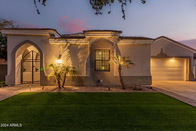 mediterranean / spanish house with a garage and a yard