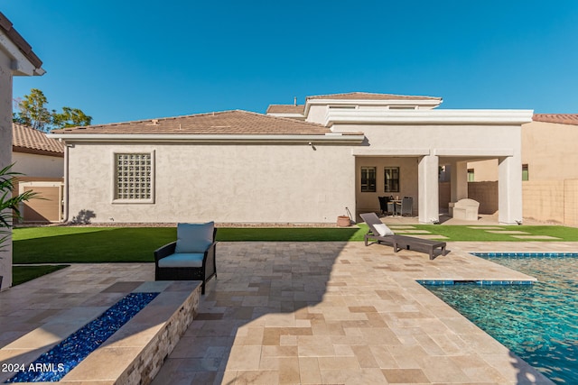 rear view of property with a patio and a fire pit