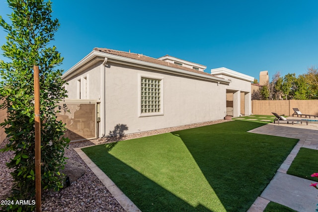 rear view of property featuring a lawn and a patio