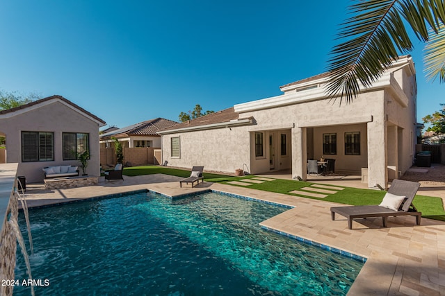 view of swimming pool featuring pool water feature, an outdoor living space, and a patio