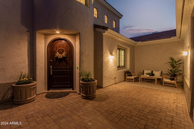 exterior entry at dusk with an outdoor living space