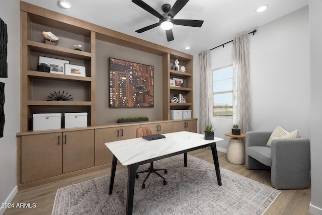 office space with ceiling fan, light hardwood / wood-style floors, and built in features