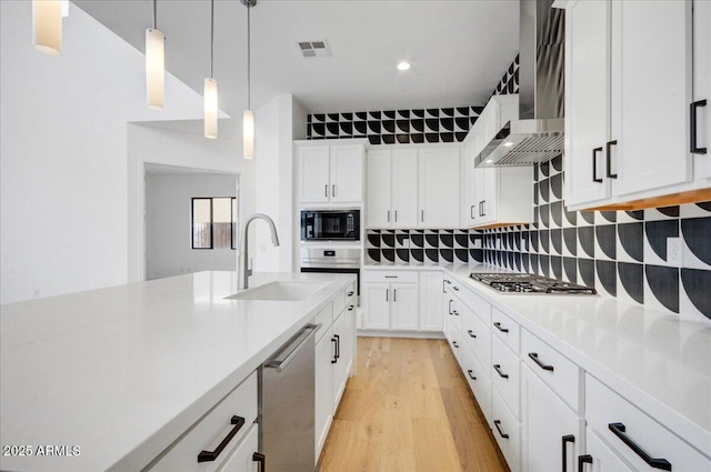 kitchen with sink, stainless steel appliances, hanging light fixtures, and white cabinets