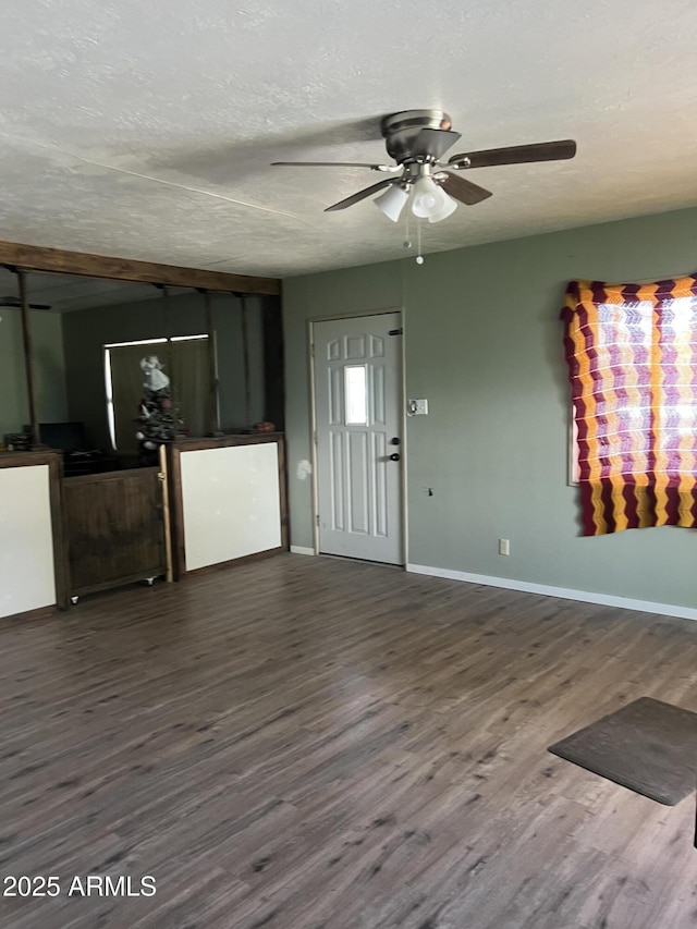 unfurnished living room featuring a textured ceiling, baseboards, a ceiling fan, and wood finished floors