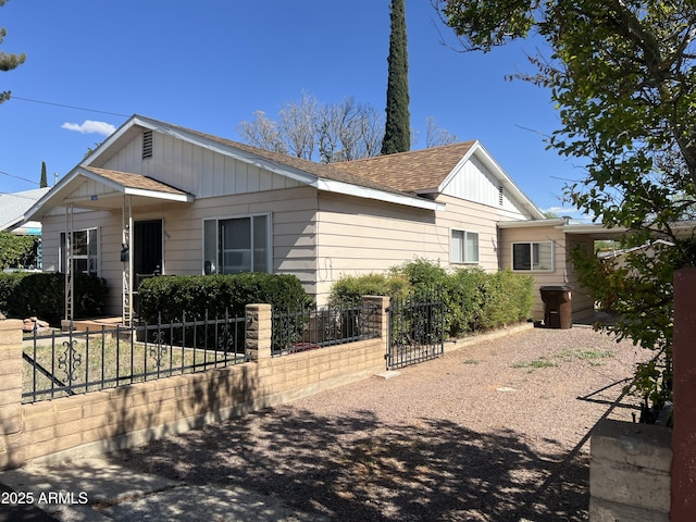 view of front of property with a gate, a fenced front yard, and roof with shingles