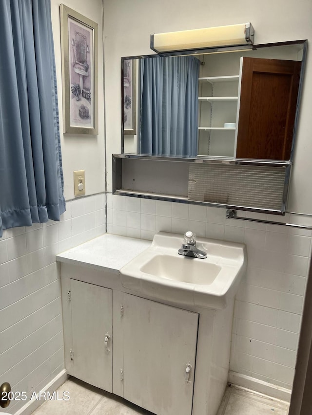 bathroom with vanity and tile walls