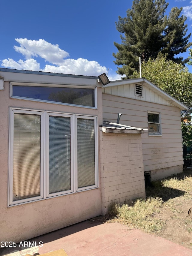 view of side of home with board and batten siding and a patio area