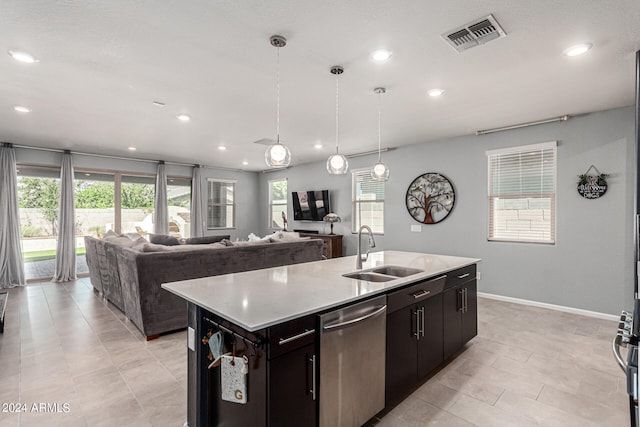 kitchen featuring hanging light fixtures, a center island with sink, sink, and stainless steel appliances