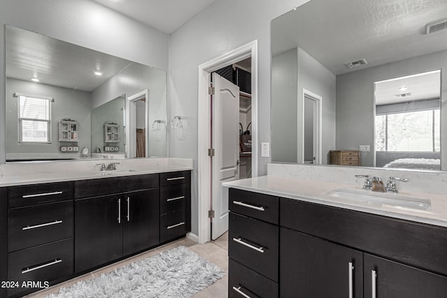 bathroom with a healthy amount of sunlight, tile patterned flooring, and vanity