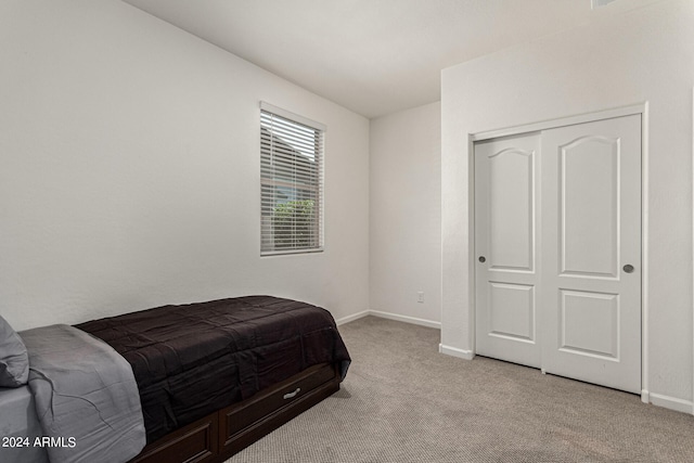 bedroom with light carpet and a closet