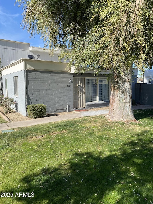 rear view of property featuring a lawn