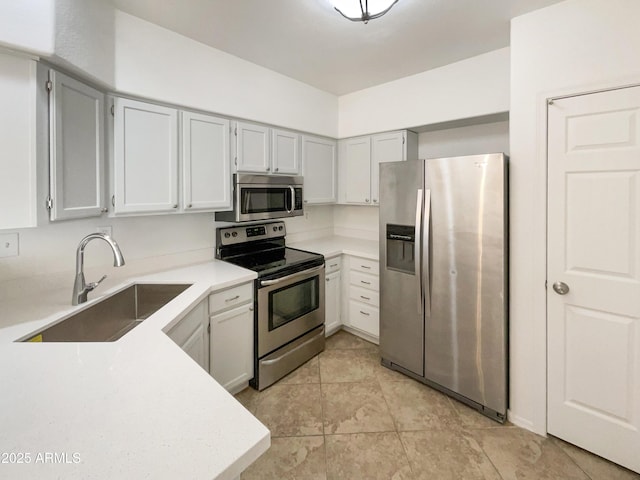 kitchen featuring stainless steel appliances, a sink, and light countertops