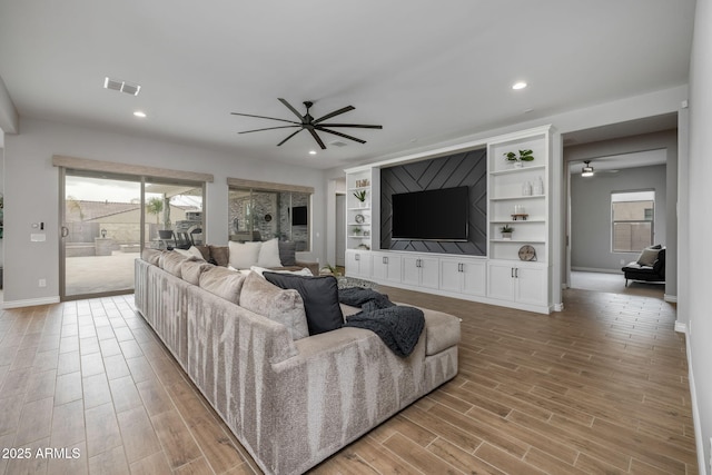 living room with ceiling fan and light wood-type flooring