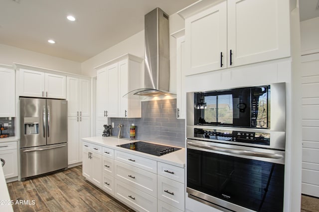 kitchen featuring white cabinetry, decorative backsplash, black appliances, and wall chimney exhaust hood