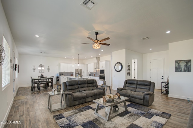 living room featuring ceiling fan and dark hardwood / wood-style floors