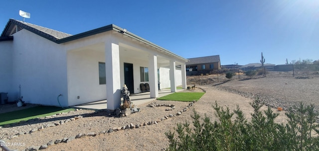 view of property exterior with cooling unit and a patio area