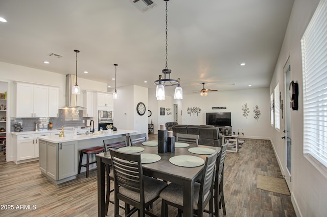 dining space featuring sink, hardwood / wood-style floors, and ceiling fan