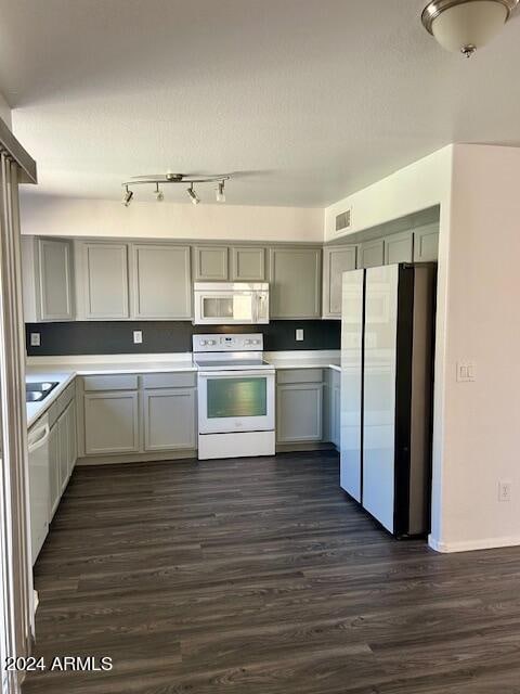 kitchen featuring white appliances, dark hardwood / wood-style flooring, and gray cabinets