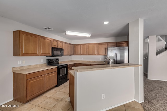 kitchen with light carpet, black appliances, sink, and a kitchen island with sink