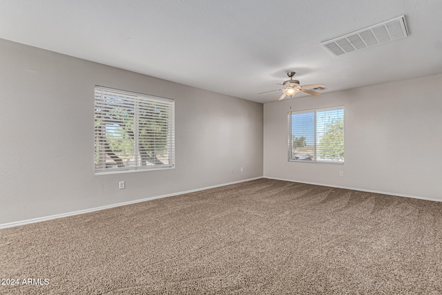 empty room featuring ceiling fan, carpet floors, and plenty of natural light