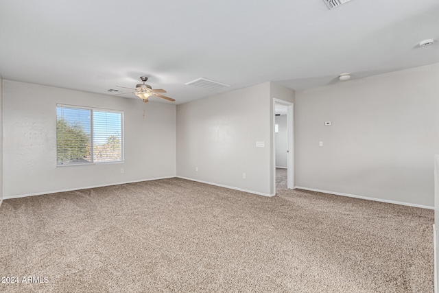 carpeted spare room featuring ceiling fan