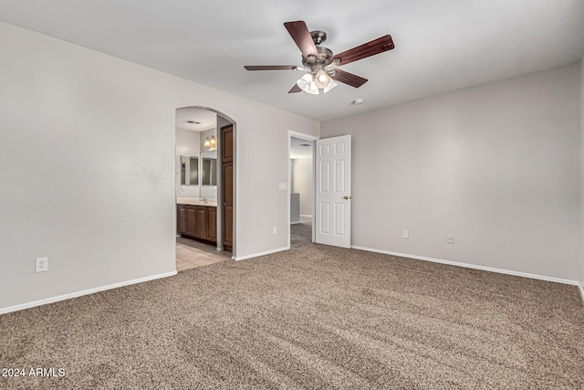 spare room with ceiling fan and light colored carpet