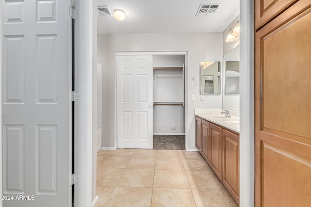 bathroom with vanity, tile patterned flooring, and a washtub