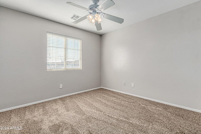 carpeted spare room featuring ceiling fan