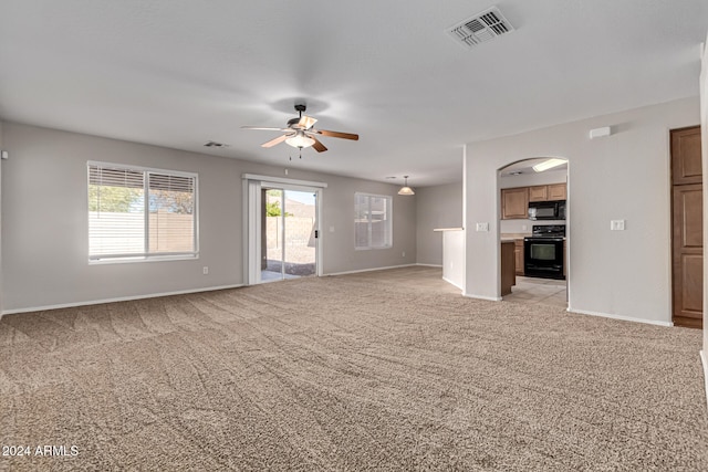 unfurnished living room featuring light carpet and ceiling fan