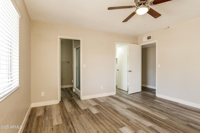 9622 N 35th Ln, Phoenix, AZ 85051 - unfurnished bedroom featuring wood finished floors, a spacious closet, a closet, and a ceiling fan