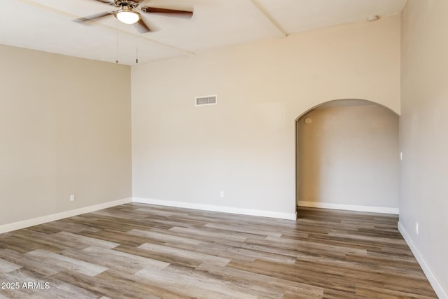 9622 N 35th Ln, Phoenix, AZ 85051 - unfurnished room featuring arched walkways, a ceiling fan, wood finished floors, and a smoke detector