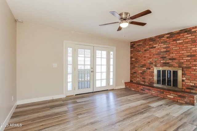9622 N 35th Ln, Phoenix, AZ 85051 - unfurnished living room featuring wood finished floors, a fireplace, and ceiling fan