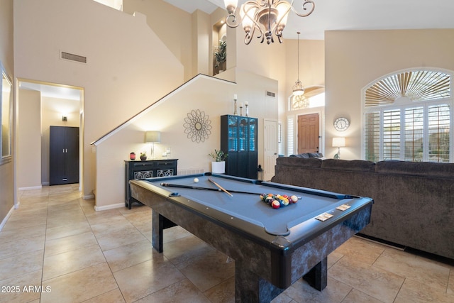 game room featuring billiards, a notable chandelier, and a high ceiling