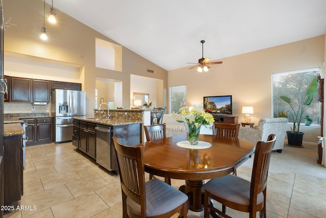 dining space with ceiling fan, high vaulted ceiling, sink, and plenty of natural light