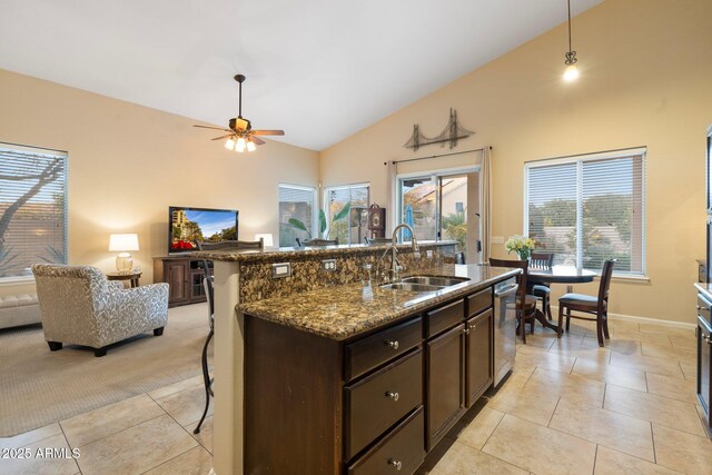 kitchen with stone countertops, lofted ceiling, sink, a breakfast bar area, and light tile patterned floors