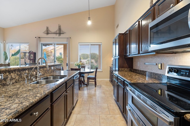 kitchen featuring pendant lighting, sink, appliances with stainless steel finishes, dark brown cabinets, and dark stone counters