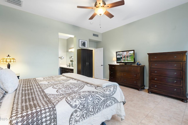 tiled bedroom featuring ceiling fan and ensuite bath