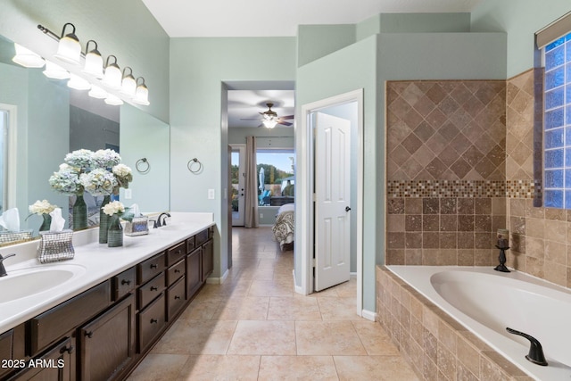 bathroom featuring vanity, a relaxing tiled tub, tile patterned floors, and ceiling fan