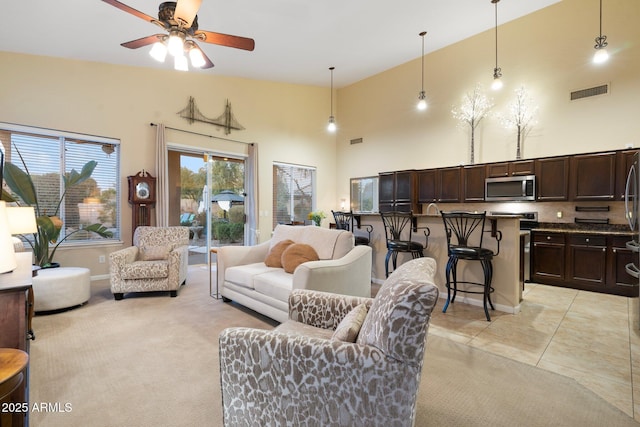 tiled living room featuring a towering ceiling and ceiling fan