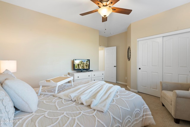 bedroom with light carpet, ceiling fan, and a closet