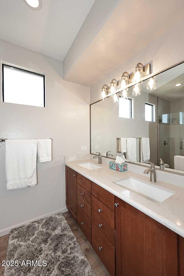 bathroom with wood-type flooring, vanity, and an enclosed shower