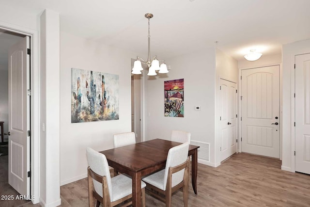 dining room featuring hardwood / wood-style floors and a notable chandelier