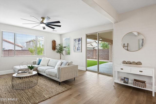 living room featuring wood finished floors, a ceiling fan, and a healthy amount of sunlight