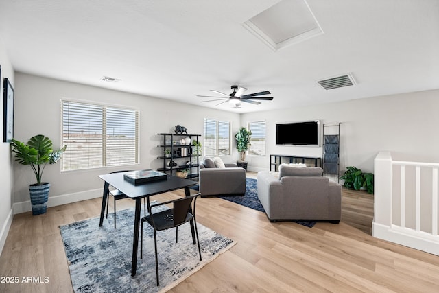 living room featuring attic access, visible vents, plenty of natural light, and light wood-style flooring