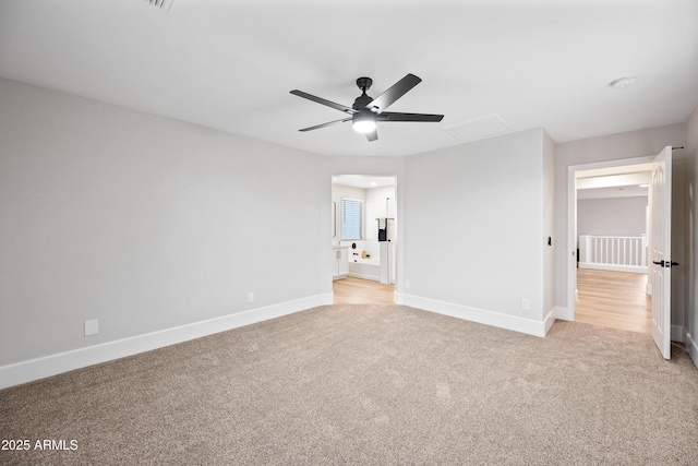 unfurnished bedroom featuring light colored carpet, connected bathroom, and baseboards