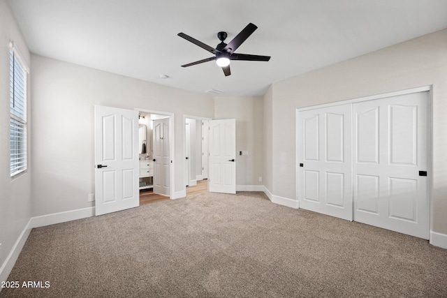 unfurnished bedroom featuring carpet floors, multiple windows, baseboards, and a closet