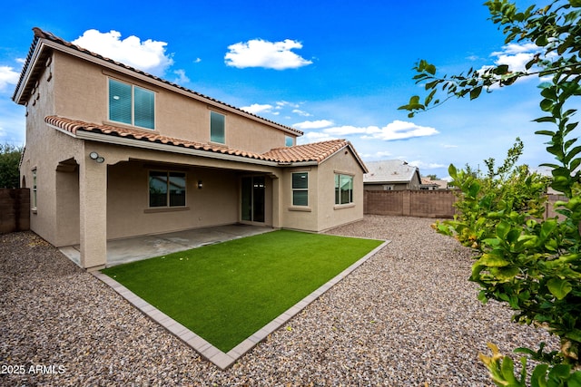 rear view of house featuring a fenced backyard, a patio, and stucco siding