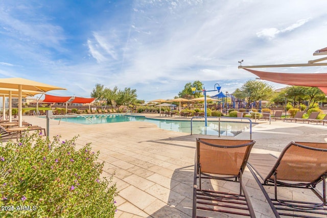 community pool with a water slide, a water play area, and a patio